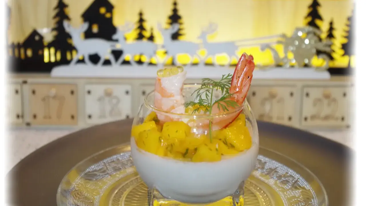 Panna cotta salée aux crevettes et mangue, décorée d'aneth. Un délice festif pour les fêtes.