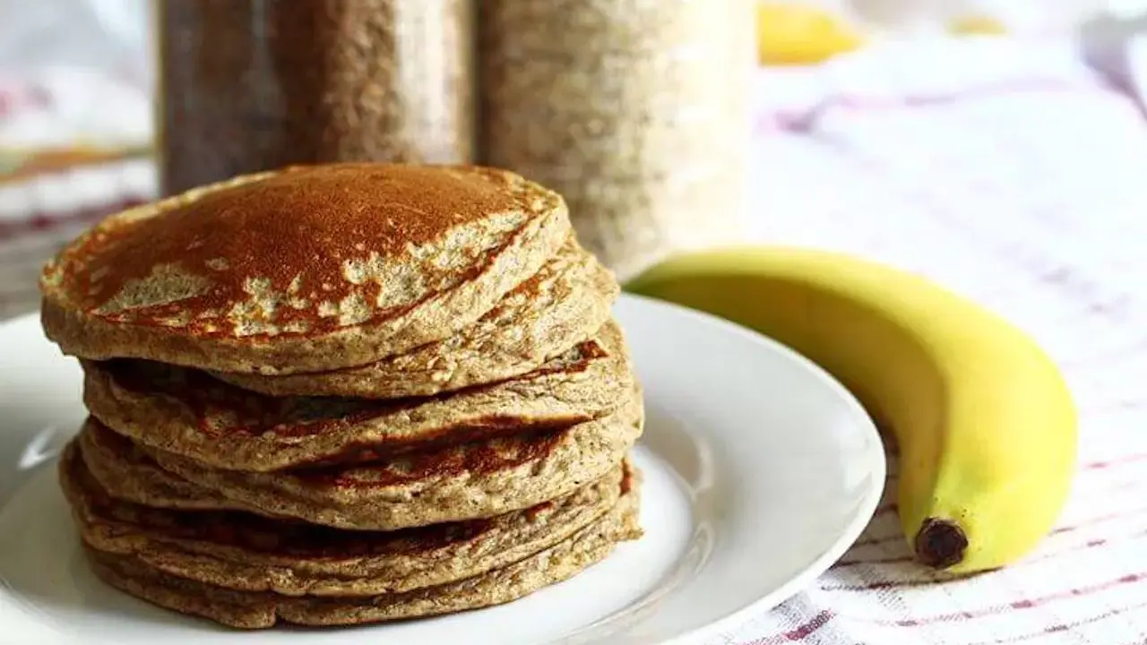 Pile de pancakes aux pois chiche, dorés et moelleux, accompagnés d'une banane. Parfait pour un petit-déjeuner sain.