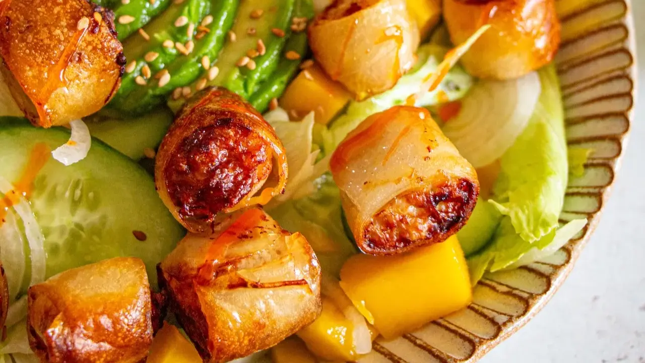 Rouleaux croustillants, avocat, mangue et concombre sur un lit de laitue. Une recette street food colorée et savoureuse.