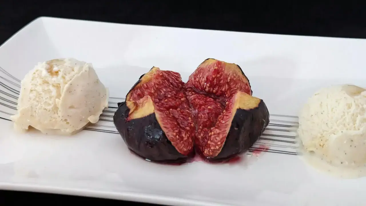 Une figue fraîche coupée en deux, servie avec deux boules de glace à la vanille. Un aperçu des 15 recettes étonnantes à la figue fraîche.