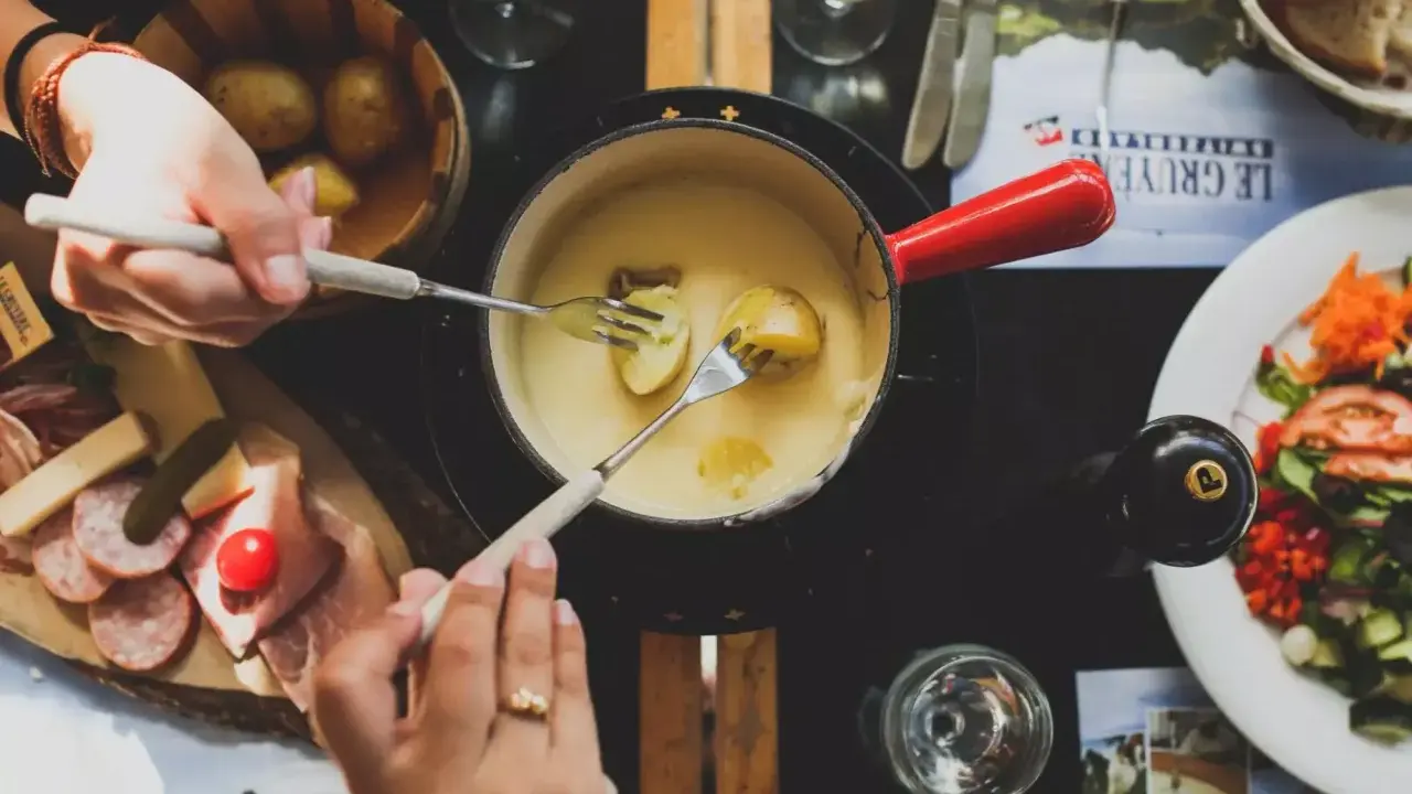 Un délicieux vin blanc pour fondue savoyarde accompagne ce plat réconfortant. Des pommes de terre et du fromage fondent dans le caquelon.