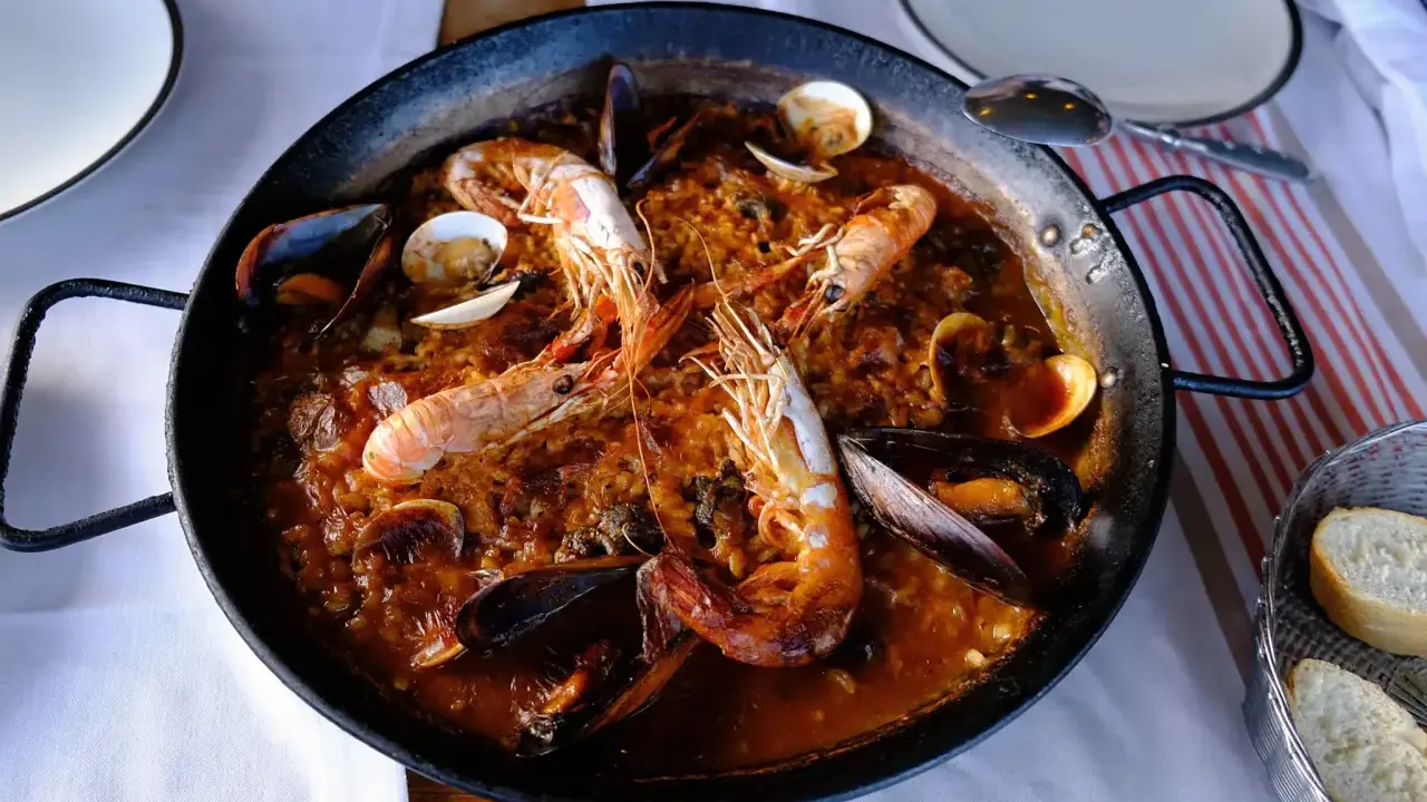 Un plat de vin avec paella aux crevettes et moules, prêt à être dégusté.