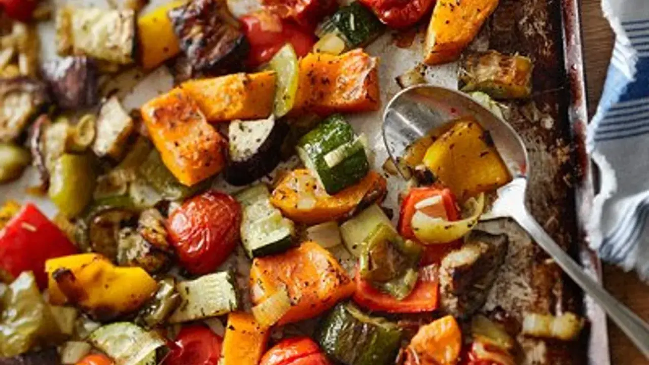 Un délicieux mélange de légumes au four : courgettes, poivrons, tomates cerises, patates douces et aubergines, assaisonnés et rôtis à la perfection.