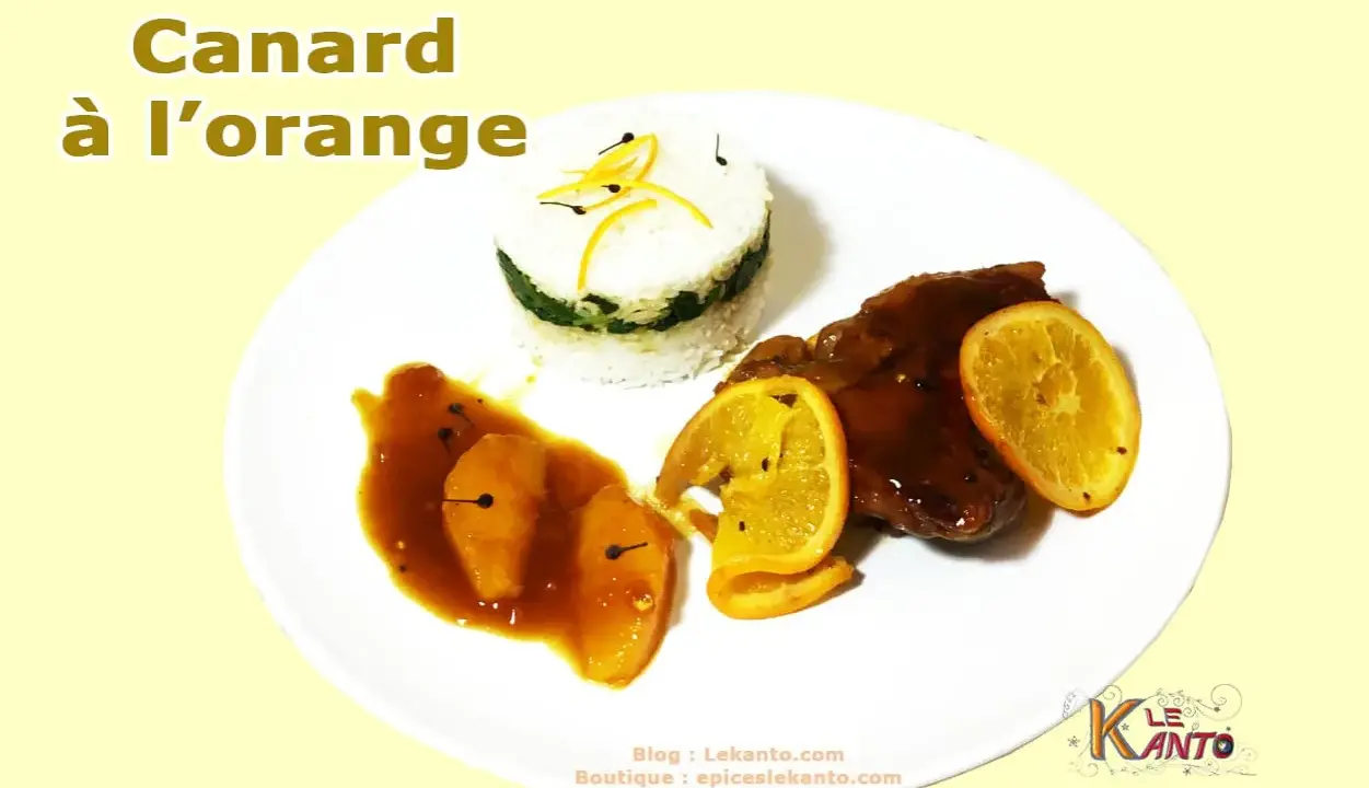 Un plat de canard à l'orange, avec du riz et des quartiers d'orange.