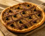 Pissaladière aux anchois et olives sur pâte brisée ou feuilletée, un délice provençal.