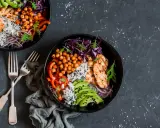Deux bols de poulet grillé, riz, avocat, pois chiches et chou rouge. Une recette avec salade verte pour un repas sain et coloré.