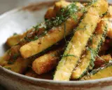Frites de courgette dorées et croustillantes, saupoudrées d'herbes fraîches et de gros sel, servies dans un bol rustique. Un délice !
