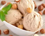 Gourmande recette glace noisette italienne. Boule crémeuse, garnie de noisettes grillées et d'une touche de menthe fraîche.