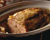 Tranche de terrine de canard dorée et appétissante, servie dans un plat en céramique.