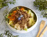 Salade fraîche et colorée avec viande hachée, carottes râpées, concombre et une touche florale. Un plat léger et savoureux.