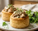 Deux bouchées à la reine poulet garnies de champignons et d'une sauce crémeuse, servies avec une salade verte.