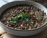Un plat de cuisson lentilles vertes, garni de persil frais et d'une feuille de laurier.