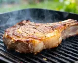 Une belle basse côte, saisie à la perfection sur le barbecue, dégage une fumée alléchante.