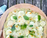Délicieuse pizza courgette, garnie de fromage fondant, de fines tranches de courgette et de feuilles de basilic frais, prête à être dégustée.