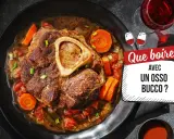 Un plat d'osso bucco savoureux, avec carottes et tomates, servi sur une assiette noire. La question "Quel vin avec osso bucco ?" est mise en avant.