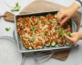 Courgettes farcies à la viande hachée, gratinées au fromage et garnies de feuilles de basilic frais. Un plat savoureux prêt à être dégusté.