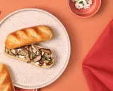 Délicieux sandwich pain au lait garni de champignons sautés et de fromage frais, parsemé de persil.