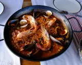 Un plat de vin avec paella aux crevettes et moules, prêt à être dégusté.