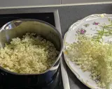 Fleurs de sureau dans une casserole et sur une assiette décorée, prêtes pour faire du sirop de sureau.
