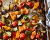 Un délicieux mélange de légumes au four : courgettes, poivrons, tomates cerises, patates douces et aubergines, assaisonnés et rôtis à la perfection.