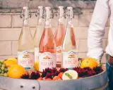 Bouteilles de cocktail vin blanc limonade citron, fruits frais et fleurs dans un tonneau.
