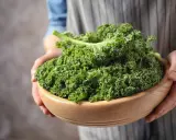 Un bol en bois rempli de chou kale frais, prêt pour une délicieuse recette italienne.