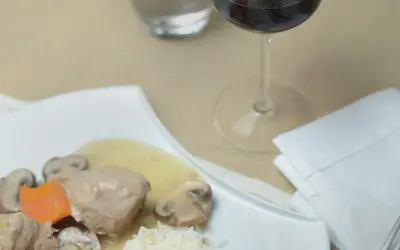 Un verre de vin rouge accompagne une blanquette de veau avec riz et champignons. Quel vin avec une blanquette de veau ?