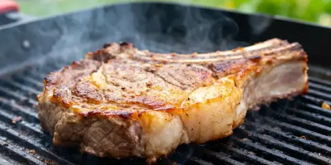 Une belle basse côte, saisie à la perfection sur le barbecue, dégage une fumée alléchante.