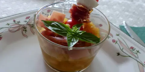 Verrine melon jambon cru : dés de melon, jambon cru, mozzarella et tomate cerise sur un pic. Une feuille de basilic décore ce délice.