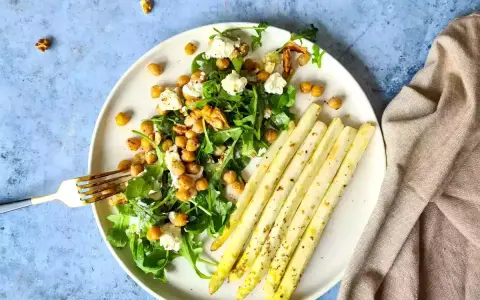 Salade de pois chiches, roquette et fromage frais, accompagnée d'asperges au four assaisonnées.