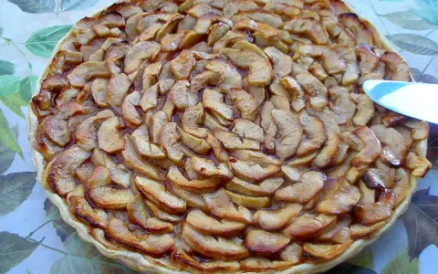 Tarte aux pommes et coings, dorée et appétissante, prête à être dégustée.