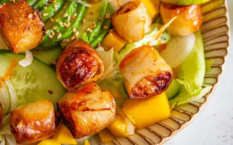 Rouleaux croustillants, avocat, mangue et concombre sur un lit de laitue. Une recette street food colorée et savoureuse.