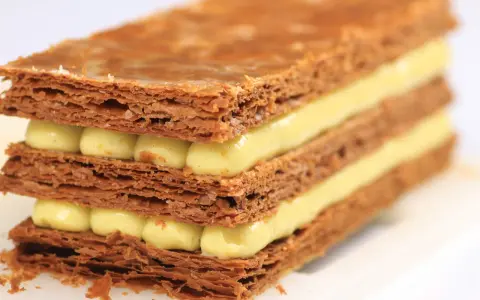 Un millefeuille croustillant aux couches de pâte feuilletée dorée et de crème pâtissière onctueuse. Une recette de mille feuille qui fait rêver.