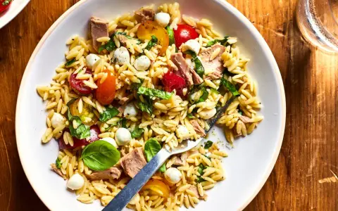 Salade de pâtes orzo avec thon, tomates cerises, billes de mozzarella et basilic frais, parfaite pour un pique-nique ensoleillé.