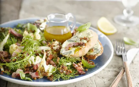 Salade verte avec chou-fleur rôti, lentilles, lardons et toasts au fromage bleu. Une idée de quoi mettre dans une salade verte pour un repas savoureux.