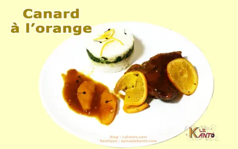 Un plat de canard à l'orange, avec du riz et des quartiers d'orange.