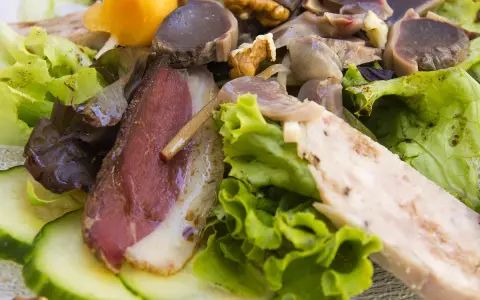 Salade landaise généreuse avec magret de canard fumé, gésiers confits, noix et légumes croquants. Un délice du Sud-Ouest.
