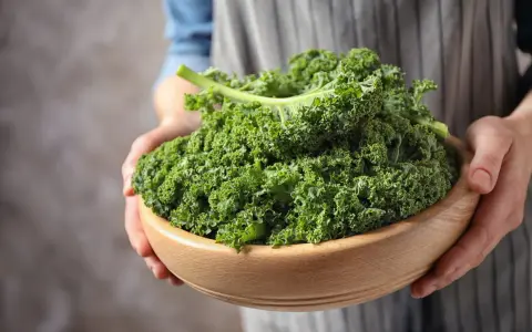 Un bol en bois rempli de chou kale frais, prêt pour une délicieuse recette italienne.