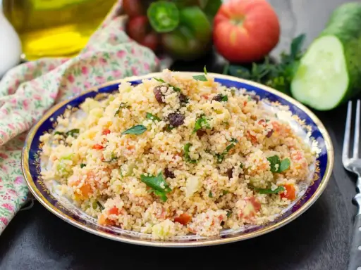 Taboulé coloré avec poivron, tomates, concombre et raisins secs. Une recette fraîche et savoureuse.