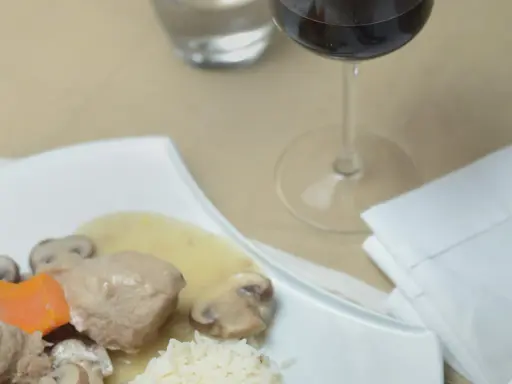 Un verre de vin rouge accompagne une blanquette de veau avec riz et champignons. Quel vin avec une blanquette de veau ?