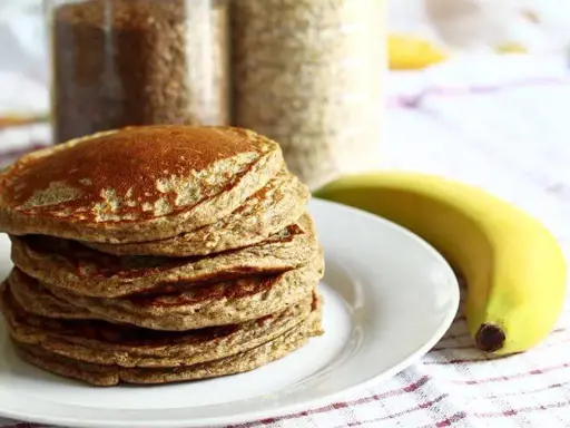 Pile de pancakes aux pois chiche, dorés et moelleux, accompagnés d'une banane. Parfait pour un petit-déjeuner sain.