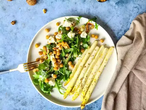 Salade de pois chiches, roquette et fromage frais, accompagnée d'asperges au four assaisonnées.