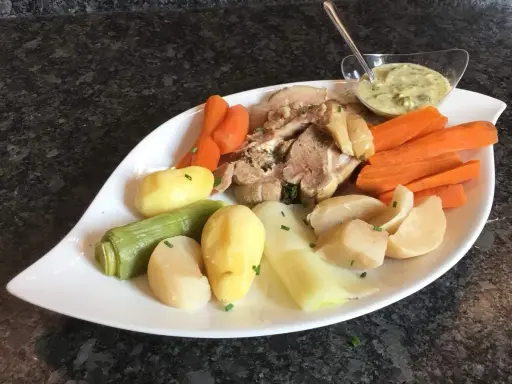 Tête de veau savoureuse accompagnée de carottes, pommes de terre et poireaux, le tout servi avec une sauce tartare crémeuse.