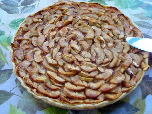 Tarte aux pommes et coings, dorée et appétissante, prête à être dégustée.