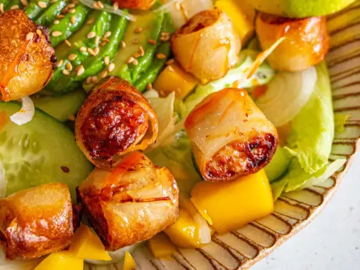 Rouleaux croustillants, avocat, mangue et concombre sur un lit de laitue. Une recette street food colorée et savoureuse.