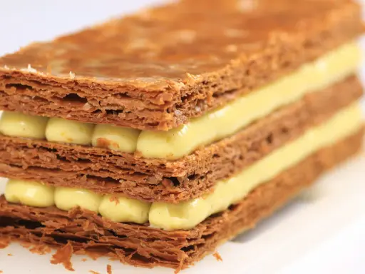 Un millefeuille croustillant aux couches de pâte feuilletée dorée et de crème pâtissière onctueuse. Une recette de mille feuille qui fait rêver.