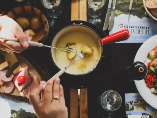Un délicieux vin blanc pour fondue savoyarde accompagne ce plat réconfortant. Des pommes de terre et du fromage fondent dans le caquelon.
