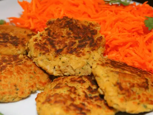 Galettes de pois chiche dorées et croustillantes, servies avec une généreuse portion de carottes râpées fraîches. Un délice végétarien !