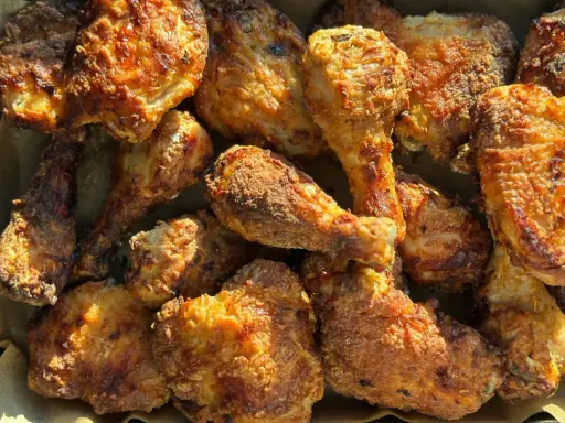 Un assortiment appétissant d'ailerons de poulet frits, dorés et croustillants, prêts à être dégustés.