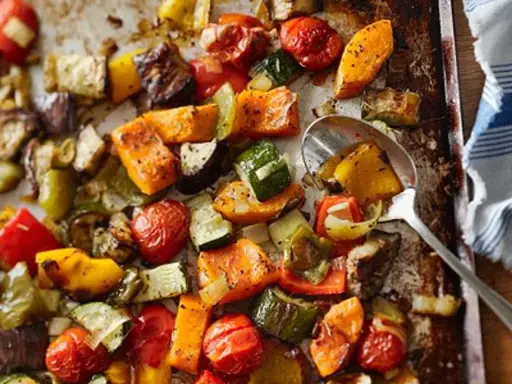 Un délicieux mélange de légumes au four : courgettes, poivrons, tomates cerises, patates douces et aubergines, assaisonnés et rôtis à la perfection.